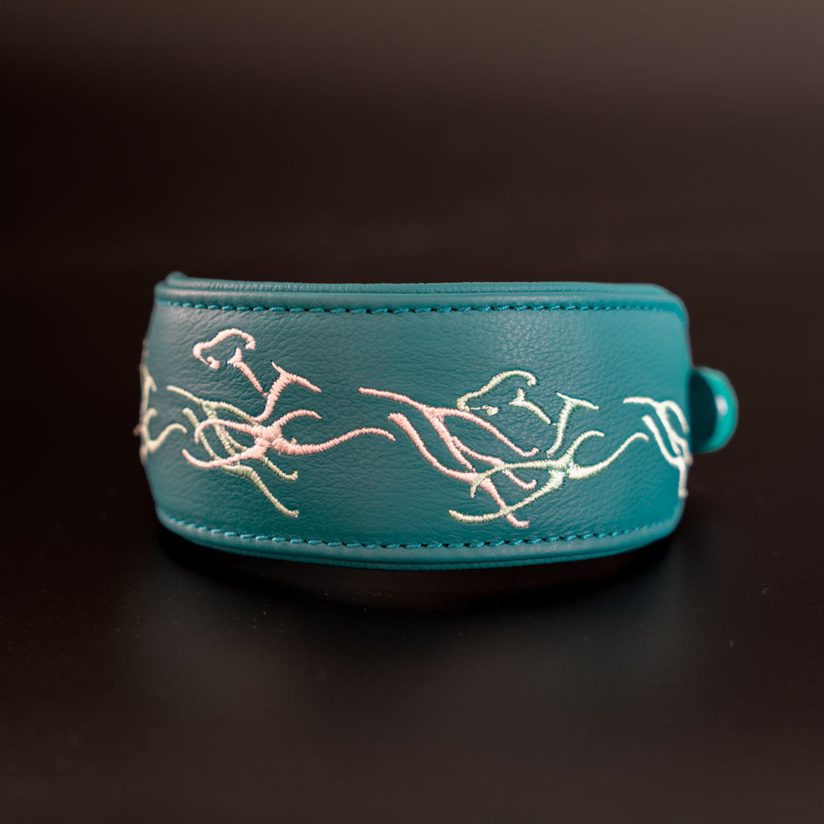 Petrolfarbenes Greyhoundline-Windhundhalsband aus Rindsnappa mit drei gestickten laufenden Greyhounds in Mint und Weiß, Frontalansicht.