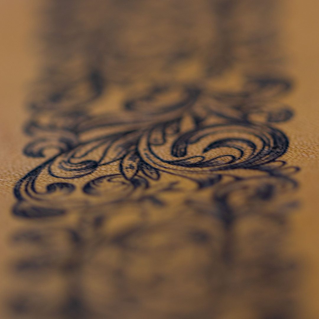 Fokus auf die Textur des Leders und das eingravierte Barock-Muster