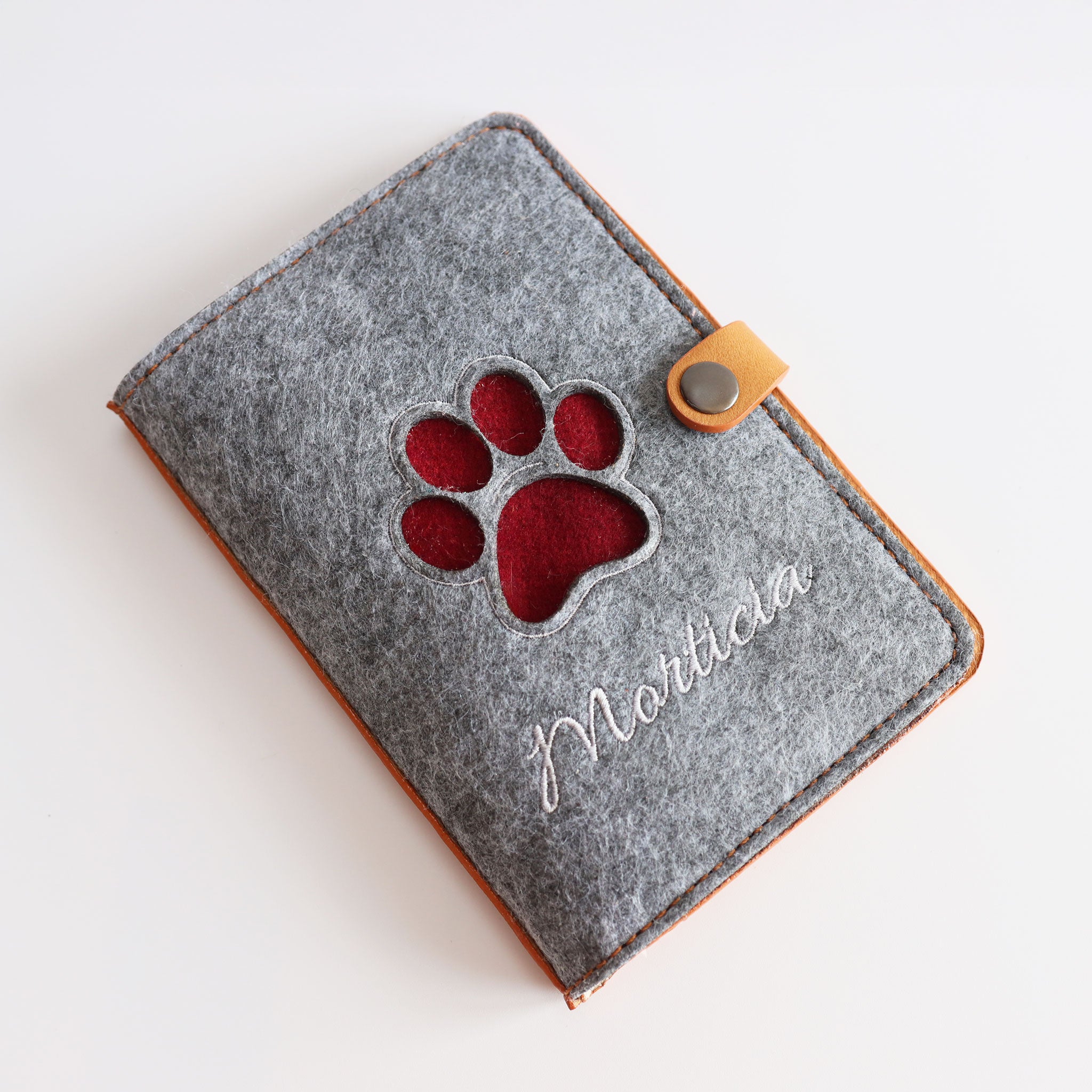 Heimtierausweishülle mit laser-cut-out in Form einer Pfote liegt flach am tisch