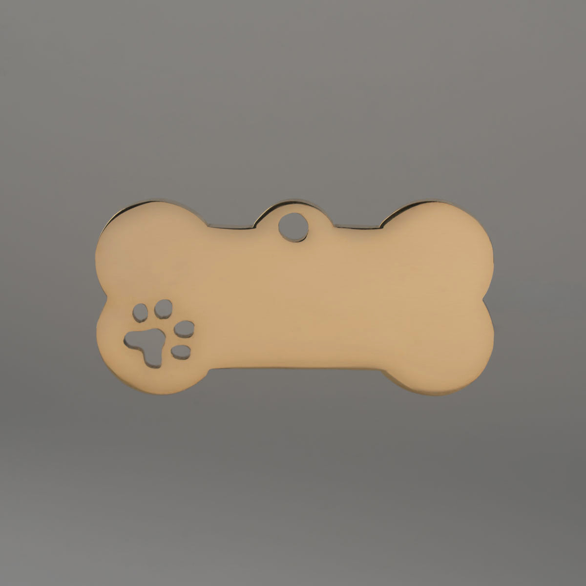 Goldfarbene Hundemarke aus Edelstahl in Knochenform, ungraviert, mit ausgeschnittenem Pfötchen.