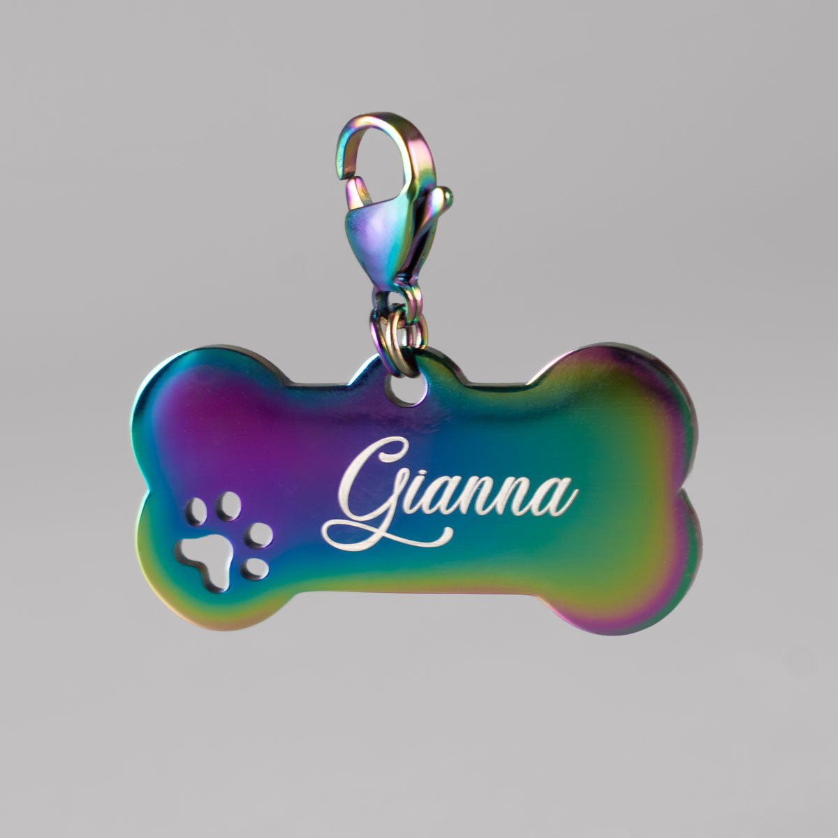 Personalisierte Rainbow-Hundemarke aus Edelstahl in Knochenform mit Pfötchen-Cut-out und weißer Namensgravur Gianna am Karabiner.