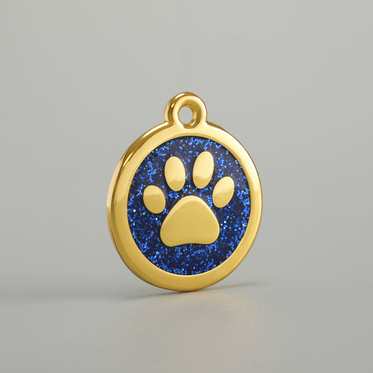 Goldene Hundemarke mit erhabener Pfote und blauer Glitzer-Epoxidharz-Hintergrund