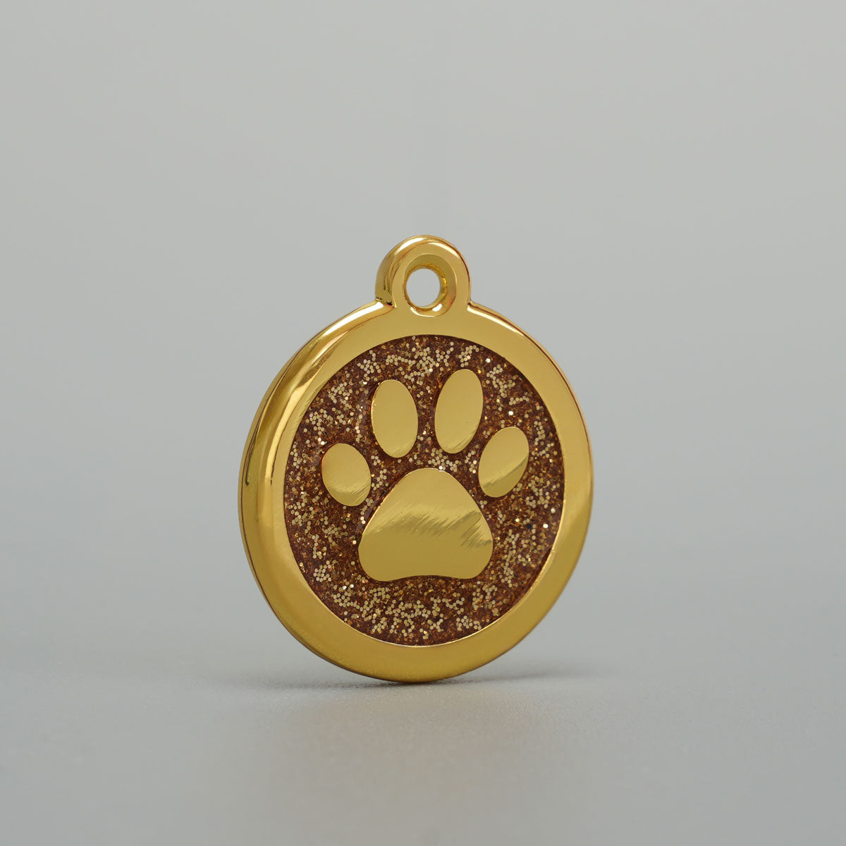 Goldene Hundemarke mit erhabener Pfote und goldener Glitzer-Epoxidharz-Hintergrund