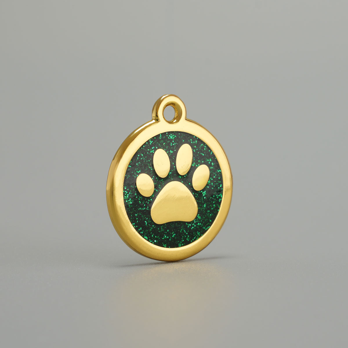 Goldene Hundemarke mit erhabener Pfote und grüner Glitzer-Epoxidharz-Hintergrund