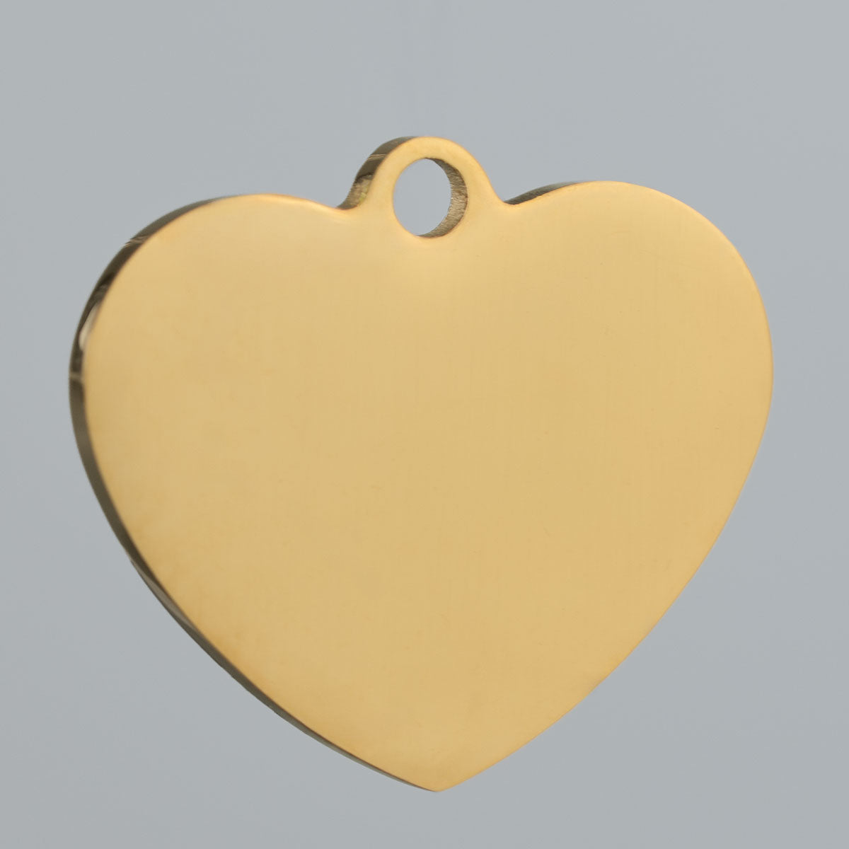 Goldfarbener Edelstahl-Rohling einer Hundemarke in Herzform, 24 × 21 mm, mit glatter Oberfläche und Befestigungsöse.