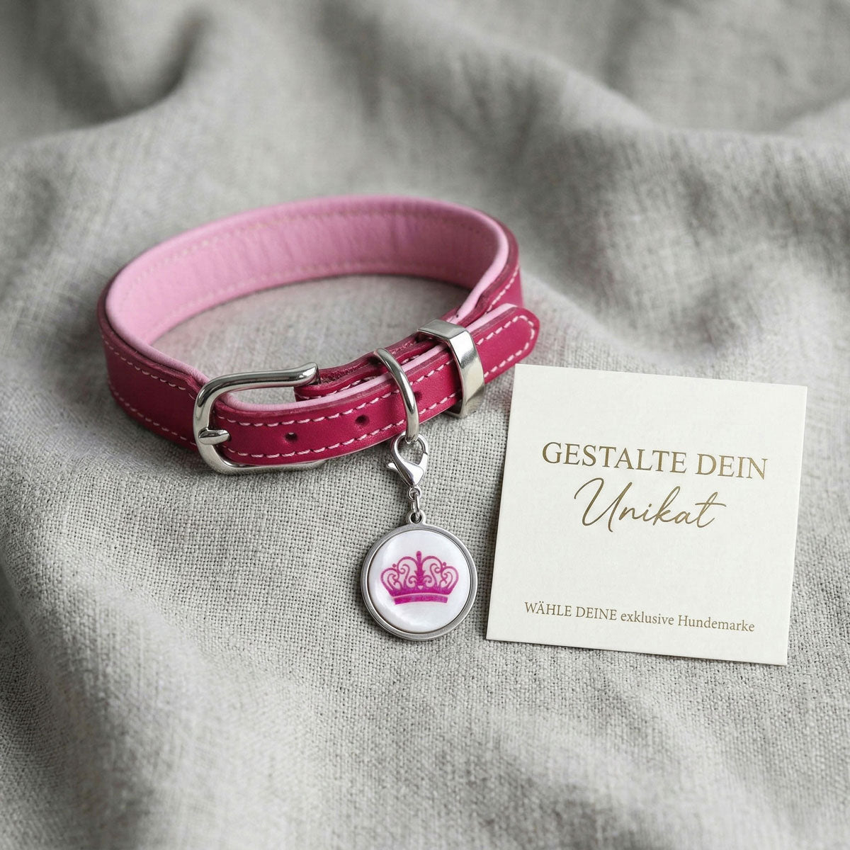 Personalisierte Hundemarke aus weißer Muschel in silberner Edelstahl-Lünette an einem magenta und pinkfarbenem Riemenhalsband.