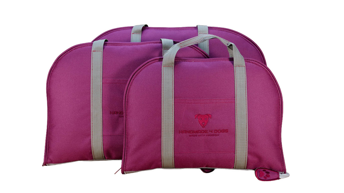 Größenvergleich dreier Dog Bed To Go Hundereisebetten in Brombeere, geschlossen als Taschen mit grauen Tragegriffen.