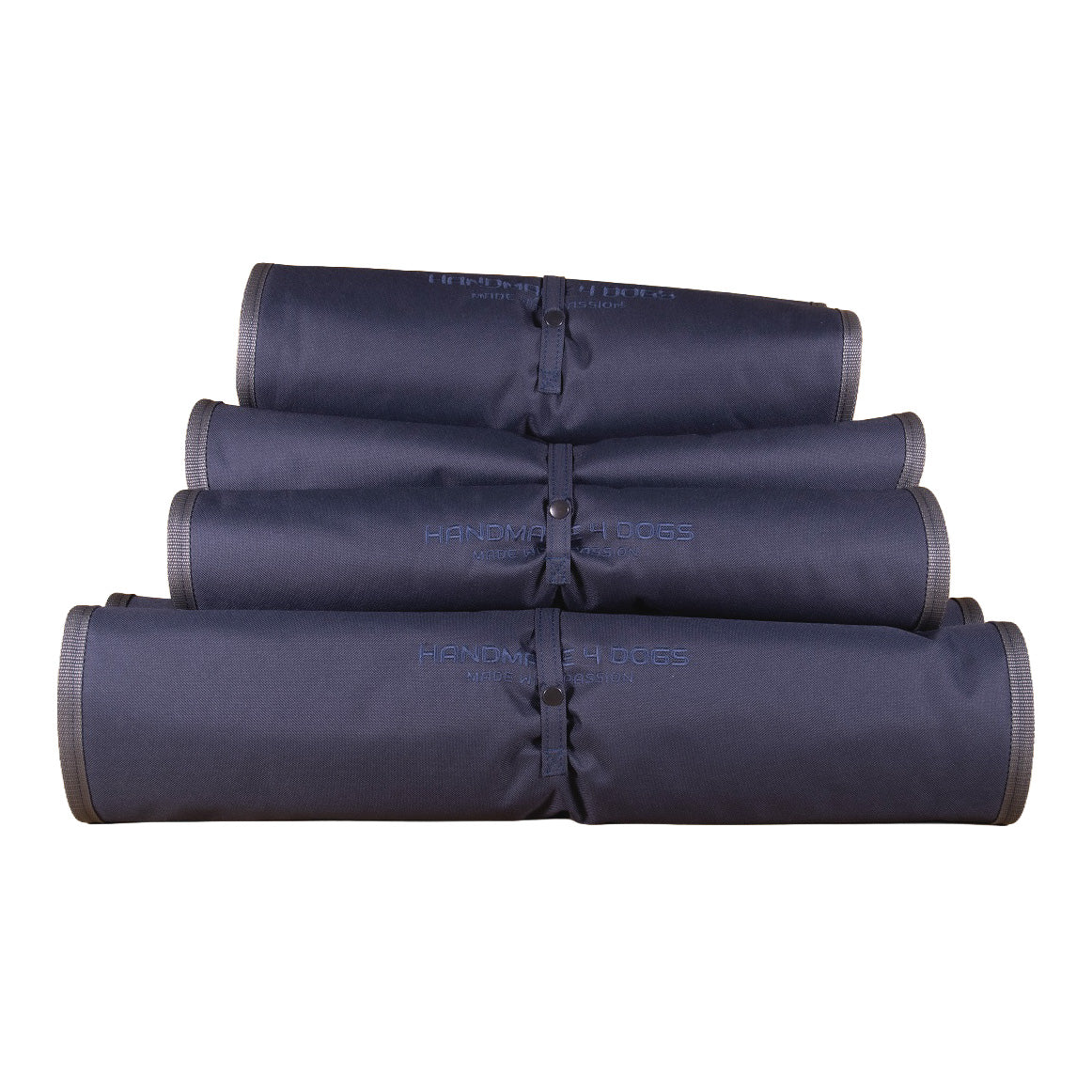 Vier zusammengerollte Dog Bed To Go LIGHT Hundereisebetten in Dunkelblau mit grauer Einfassung, Verschlusslaschen und gesticktem handmade4dogs Logo.