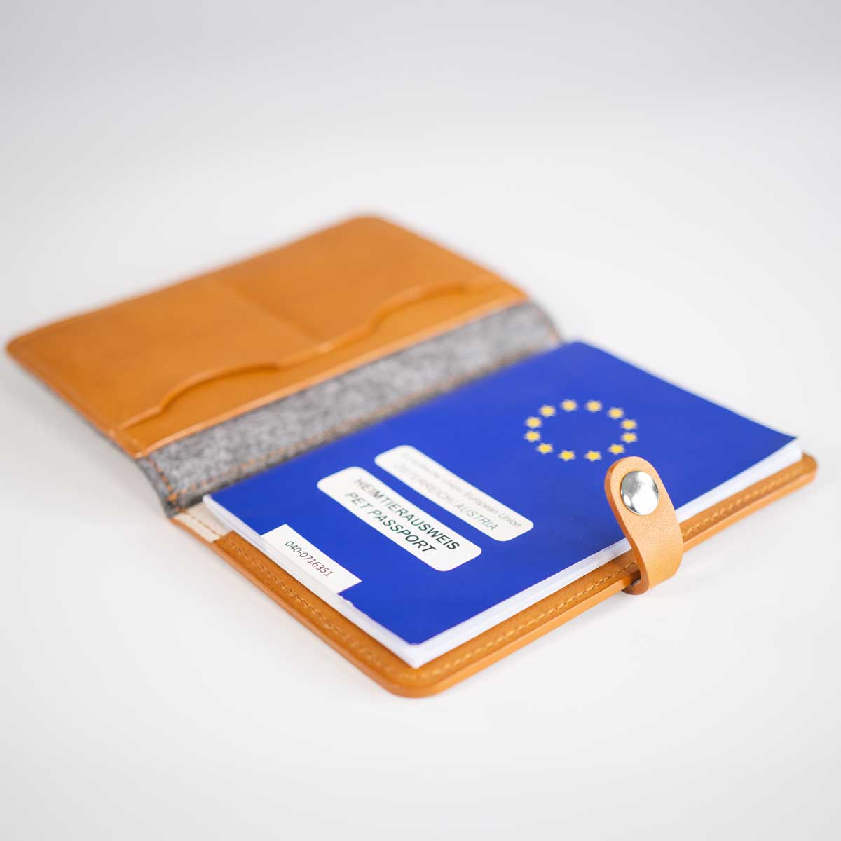 Detailansicht der befüllten Impfpasshülle, die den sicheren Halt des EU-Heimtierausweises im Lederfach demonstriert.