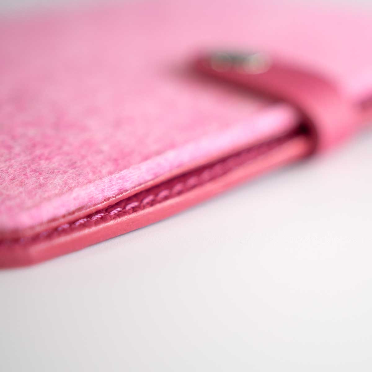 Nahaufnahme der handwerklich perfekt geschliffenen, lackierten und auf Hochglanz polierten Kanten der pinken Kombi-Hülle.