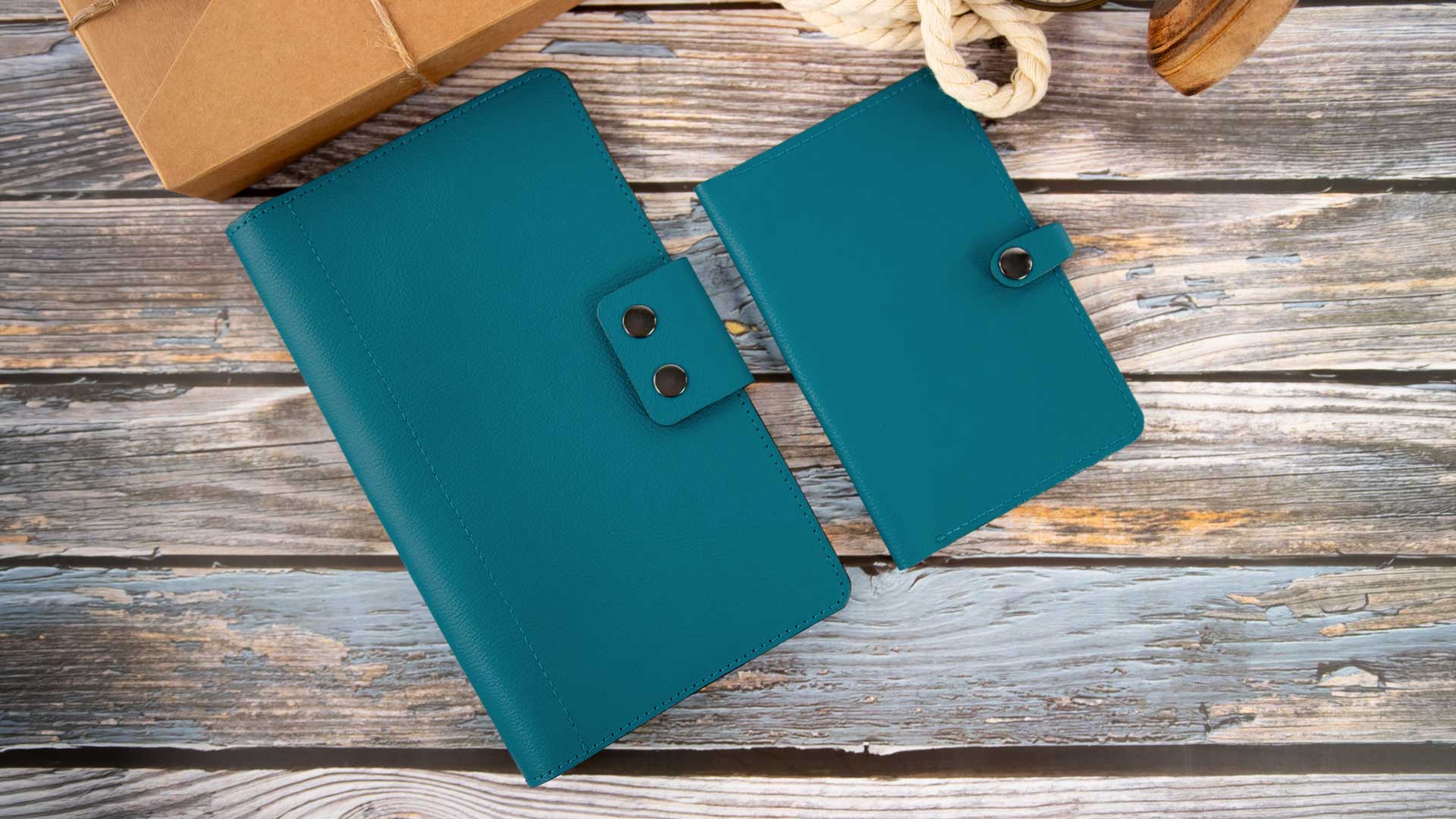 Stilvoller Vergleich zwischen dem großen Leder-Travel-Wallet für Dokumente und der kompakten Heimtierausweishülle im passenden Petrolton.