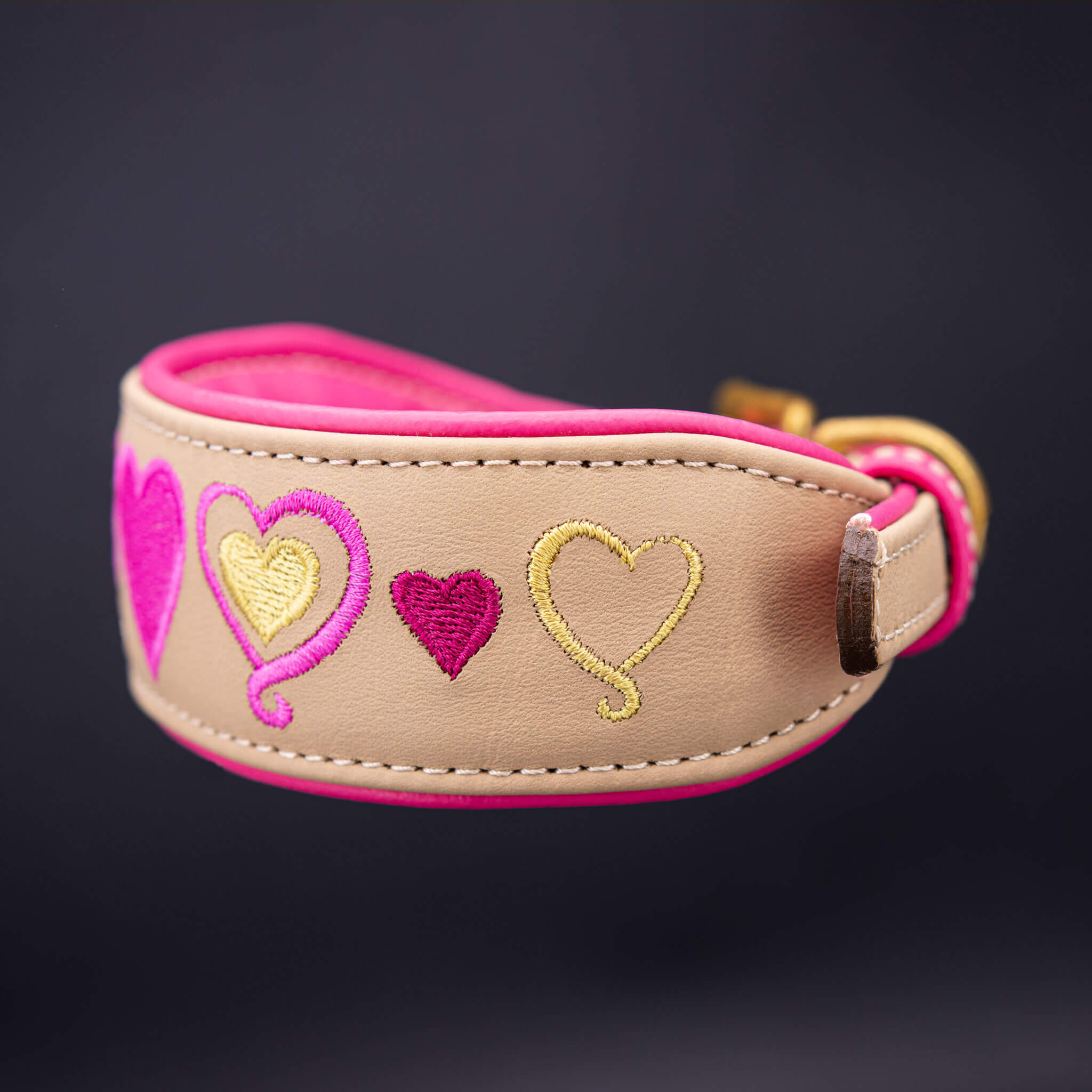 Handgefertigtes Lederhalsband für Hunde mit Herz-Stickerei in Pink und Gold auf sandfarbenem Grund