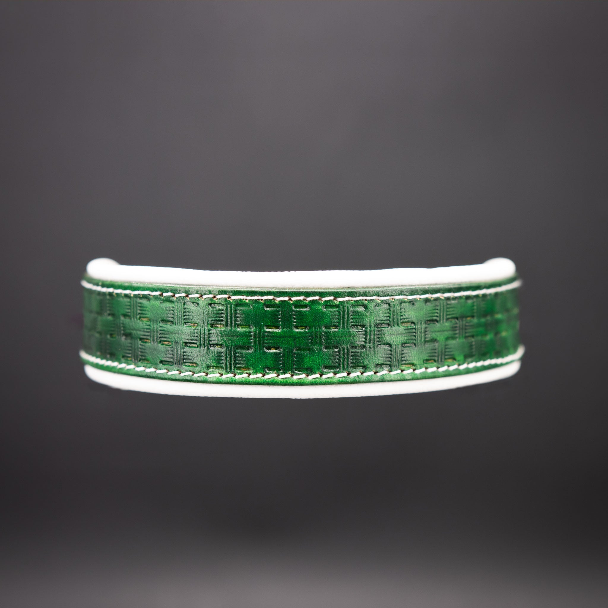 Detailaufnahme der handgefertigten Web-Punzierung auf grünem Rindsleder