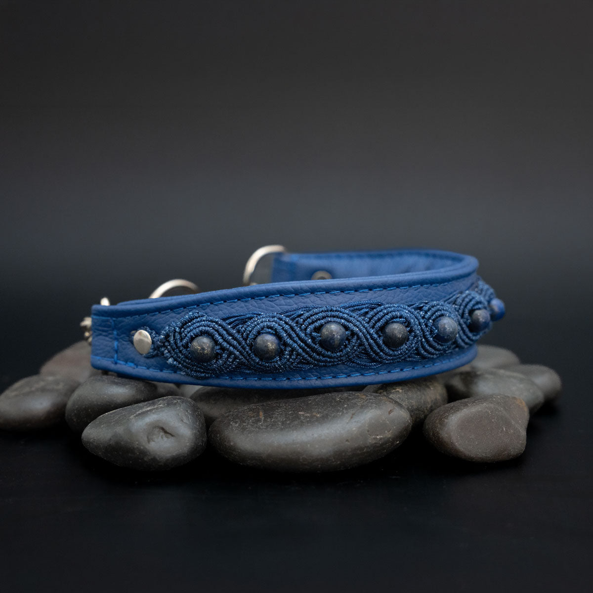 Schräge Seitenansicht des Lapislazuli-Halsbands mit blauer Knüpfborte, verjüngtem Lederende und silberfarbener Befestigung links.