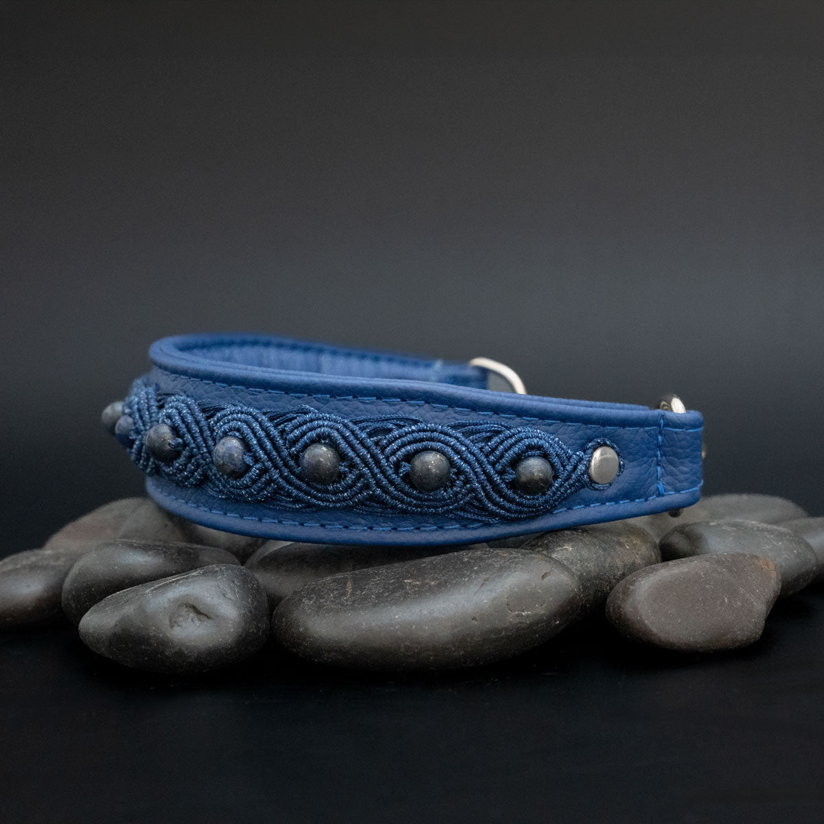 Seitenansicht des ultramarinblauen Lederhalsbands mit Lapislazuli in ovalen Makramee-Motiven und silberfarbener Befestigung rechts.