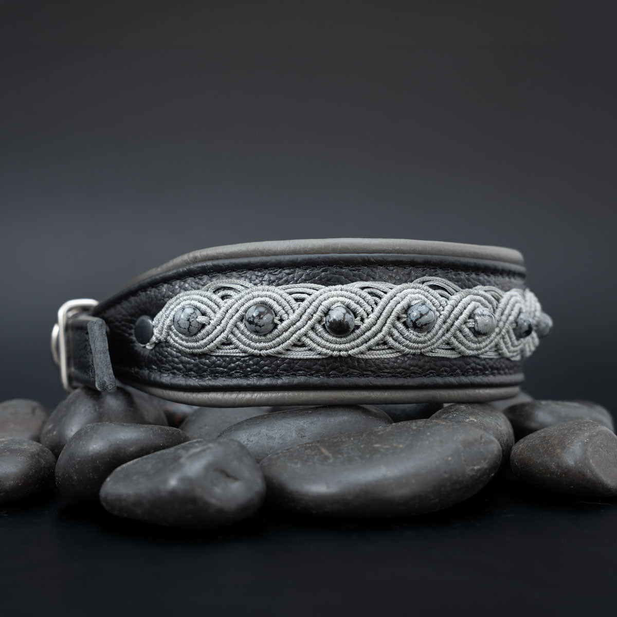Schwarzes Halsband mit silberfarbener Knüpfborte und Schneeflockenobsidian; rechts verjüngt sich das Leder zur Schnalle.
