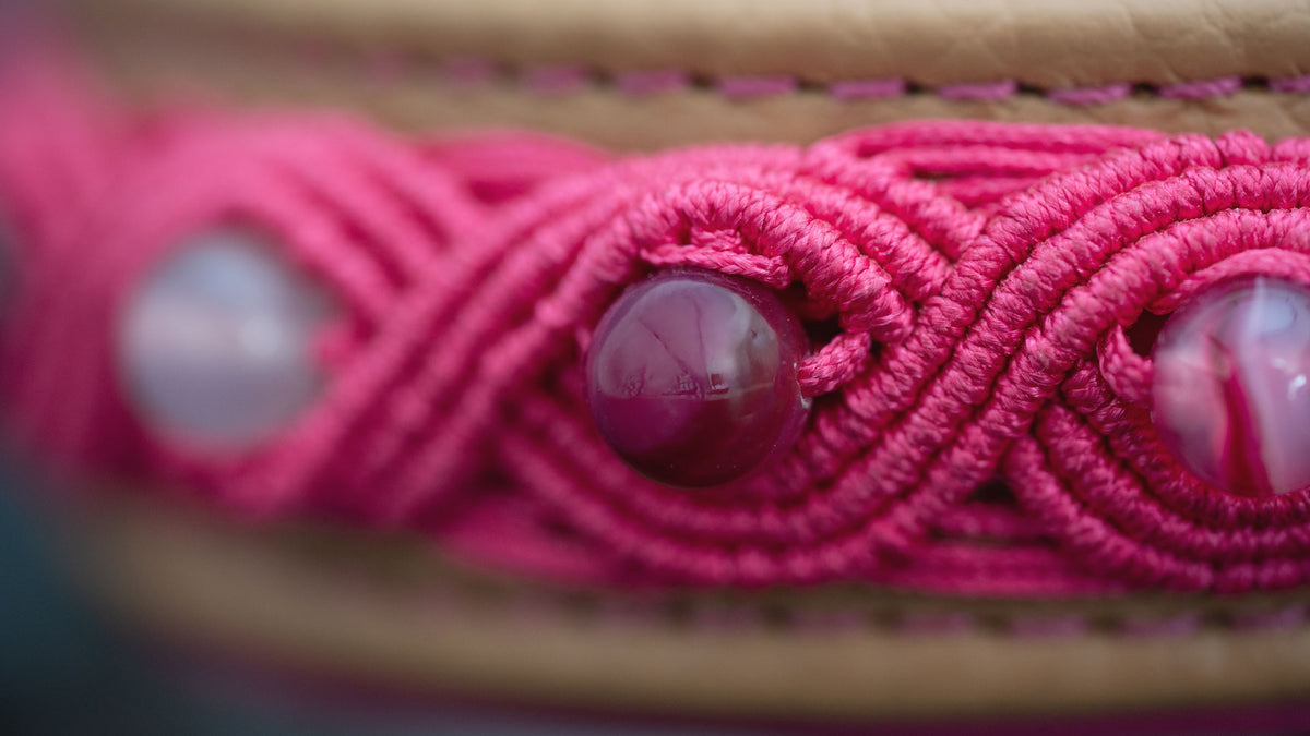 Makroaufnahme eines Streifenachats in pinker Micro-Makramee auf der cappuccinofarbenen Lederfront des Hundehalsbands.