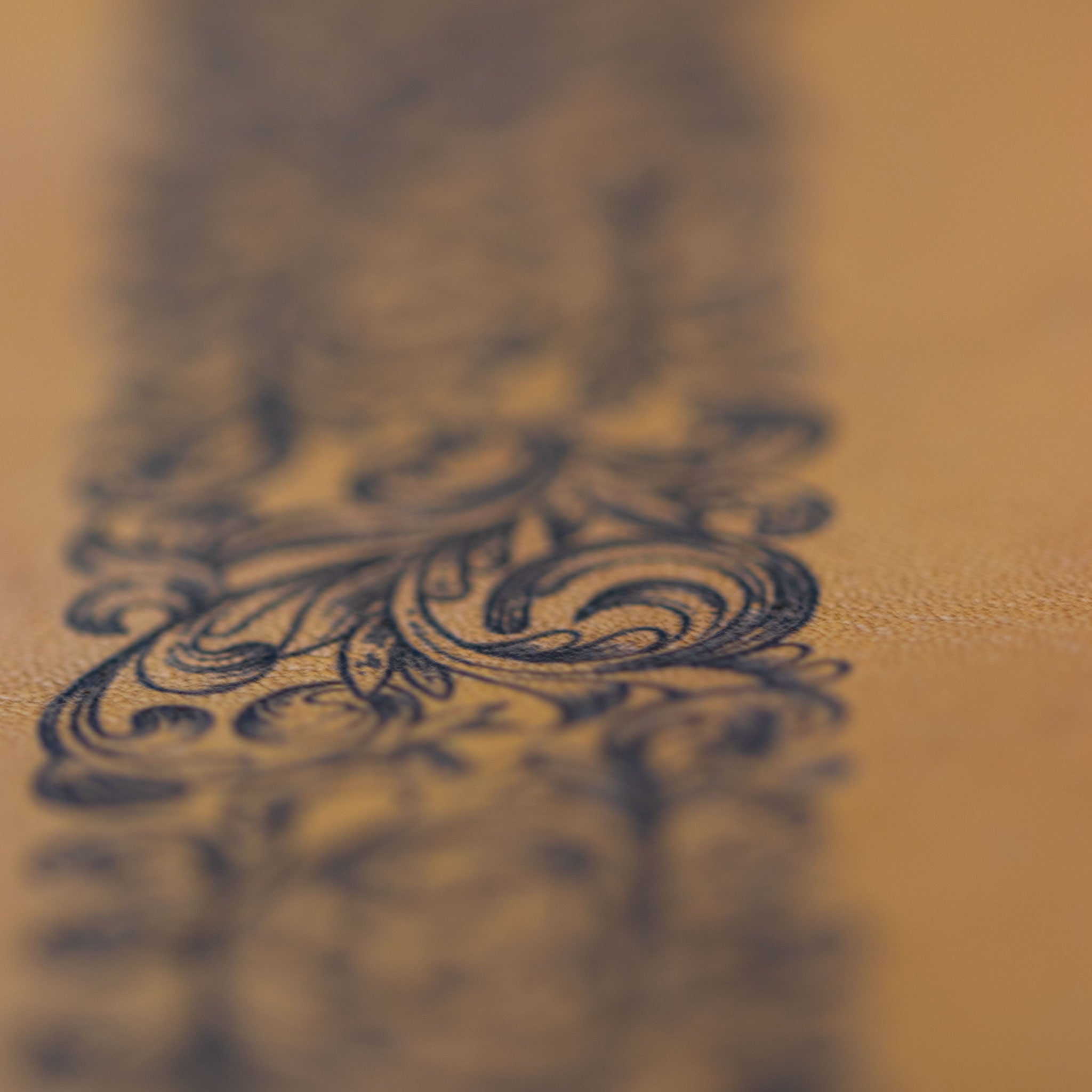 Makroaufnahme der präzisen Barock-Lasergravur auf dem Rindleder