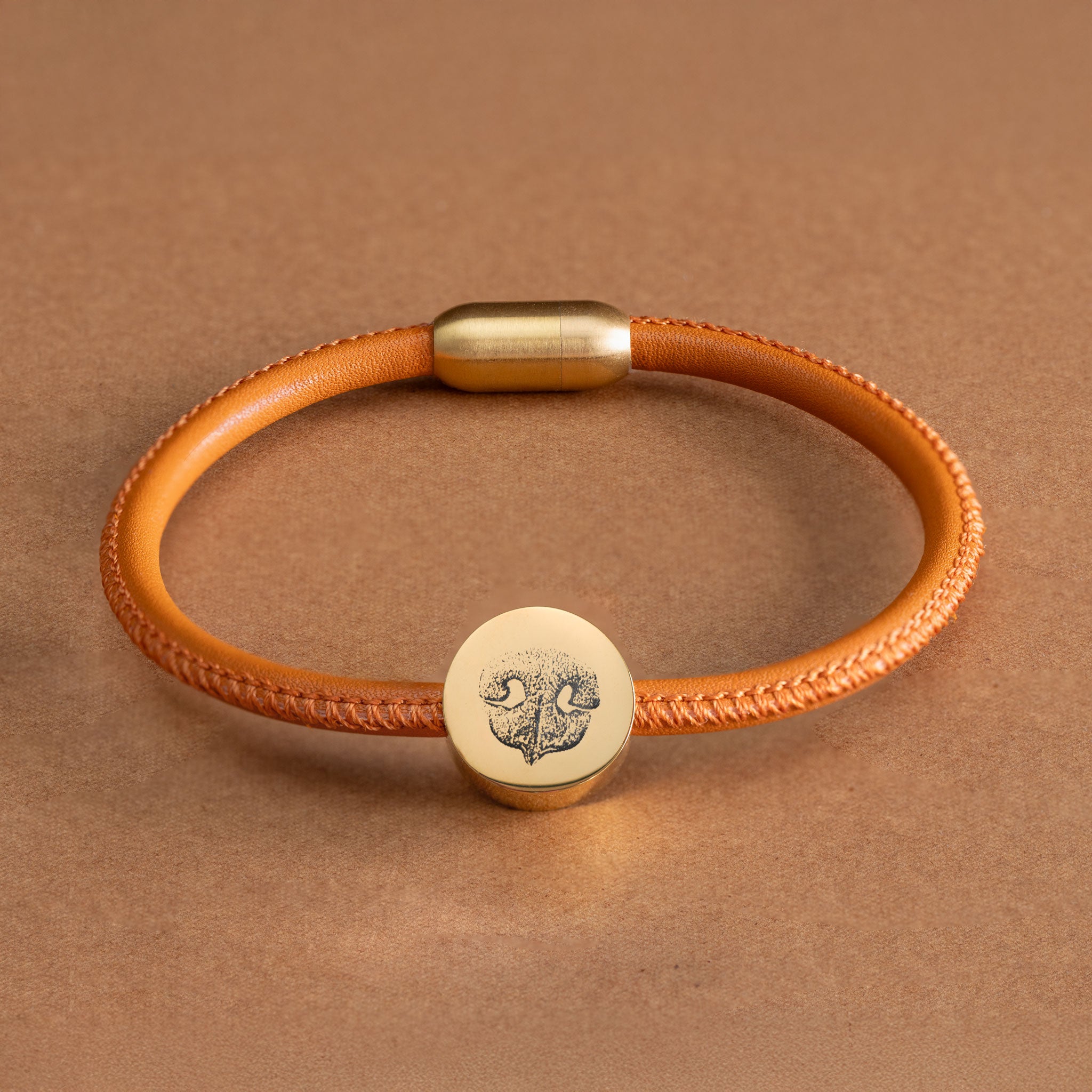 Personalisiertes Lederarmband aus cognacfarbenem Lammnappa mit einer goldenen Perle und detaillierter Hundenasen-Gravur