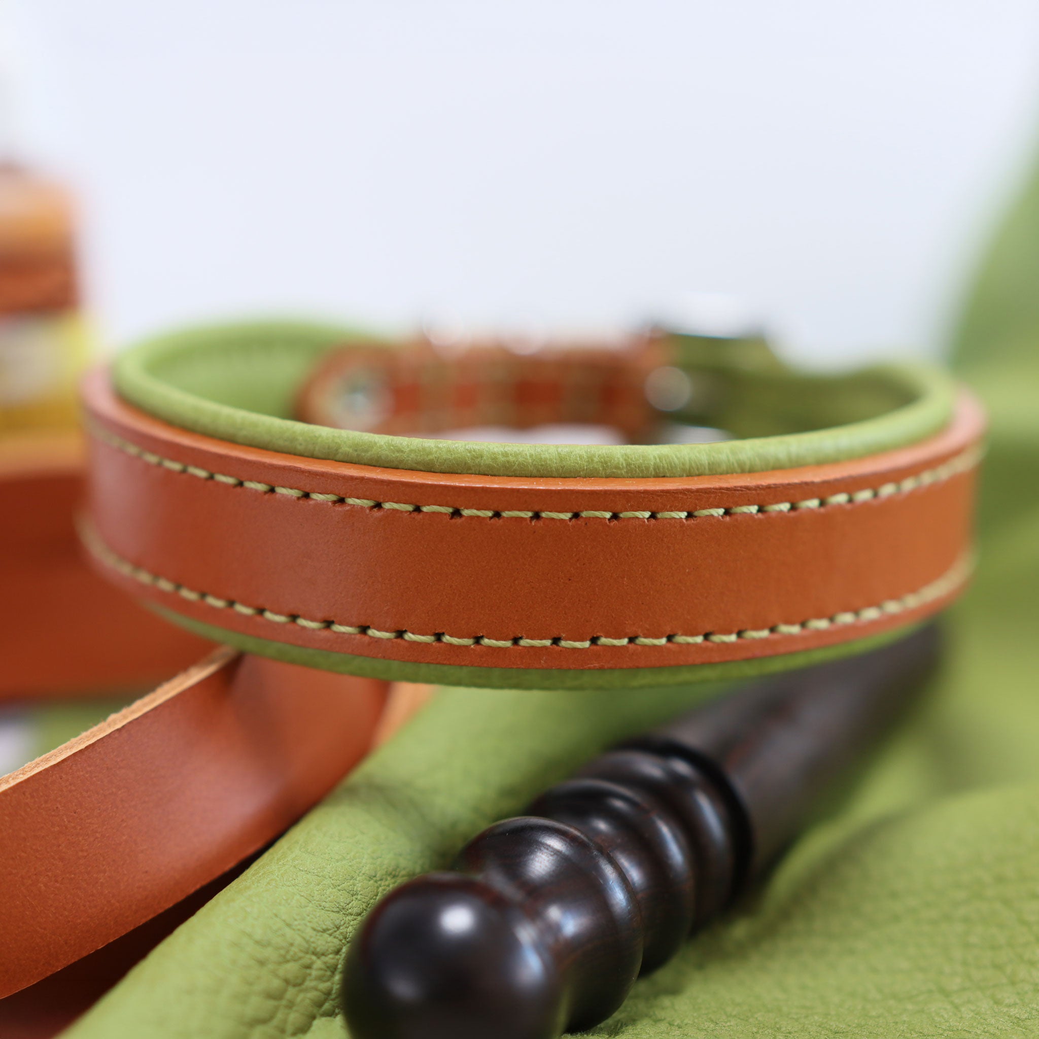 Exklusives Lederhalsband Natur-Grün präsentiert mit Lederwerkzeug