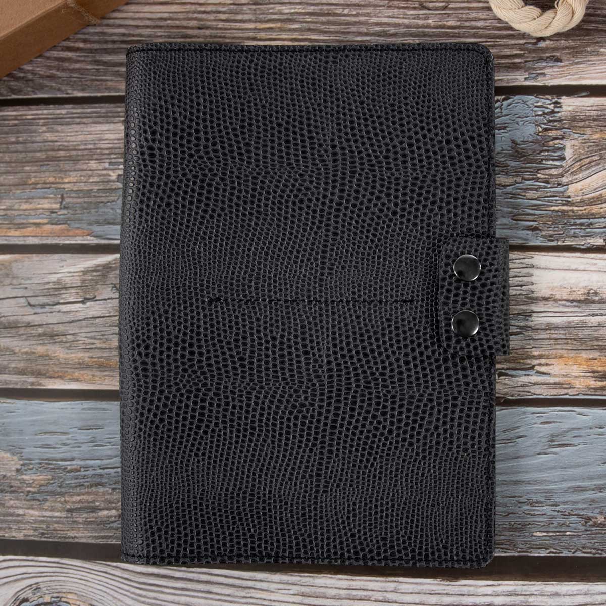 Geschlossenes Travel Wallet für vier Pässe aus asphaltgrauem Rindsleder mit feiner Echsenprägung. Die Verschlusslasche mit gunfarbenen Druckknöpfen rundet das elegante Design ab.