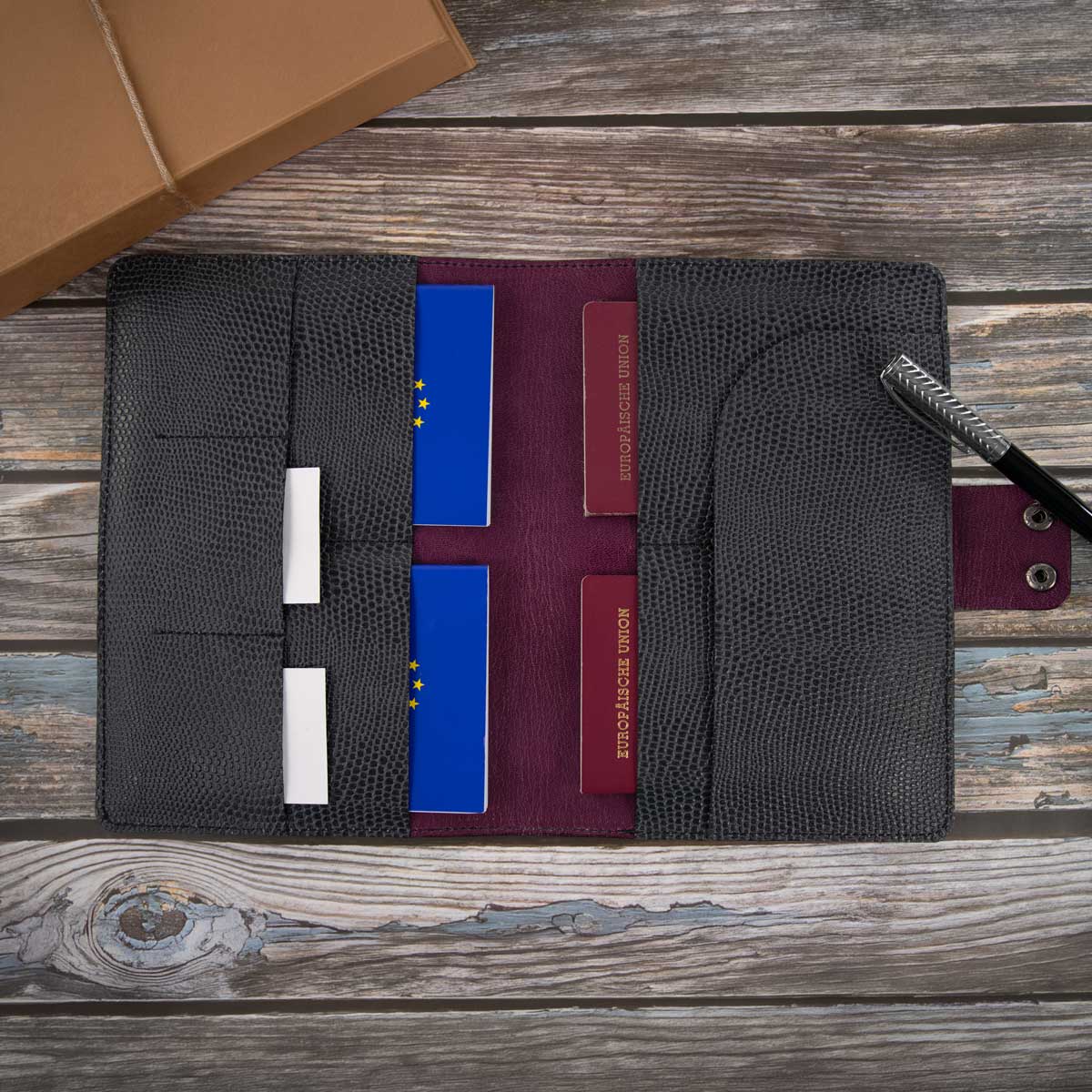 Das befüllte Travel Wallet im Echsen-Look zeigt sein großzügiges Platzangebot, das bequem für vier Reisepässe oder EU-Heimtierausweise sowie Reiseunterlagen ausreicht