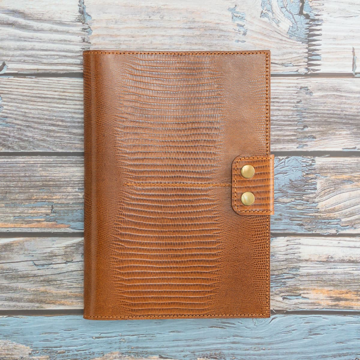 Handgefertigtes Reise-Etui aus cognacfarbenem Kalbsleder mit edler Echsenprägung. Geschlossen wird das Travel Wallet mit zwei antiken Messing-Druckknöpfen.