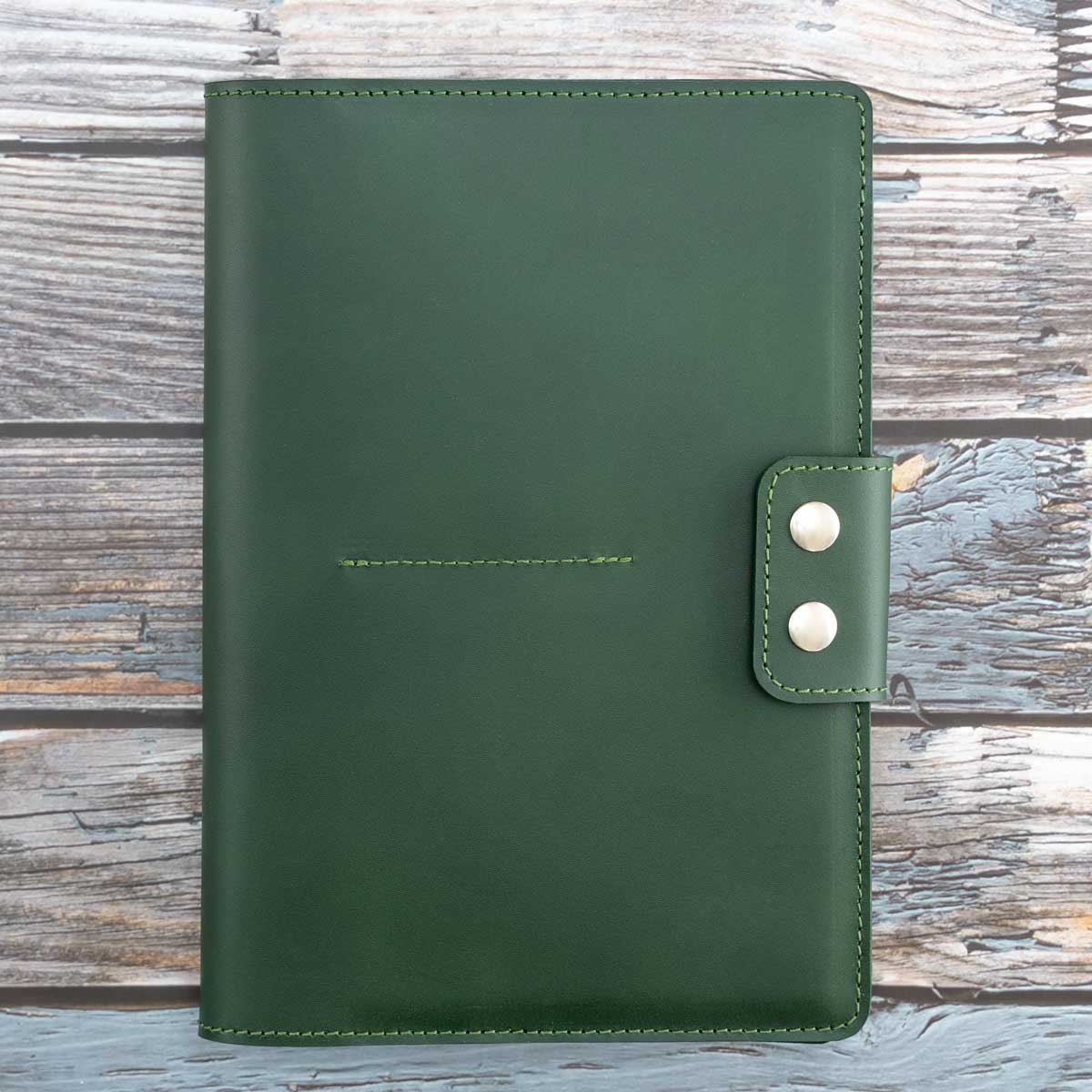 Handgefertigtes Travel Wallet für vier Pässe aus robustem, dunkelgrünem italienischem Taschenleder. Geschlossen wird das Reise-Etui mit zwei markanten silberfarbenen Druckknöpfen.