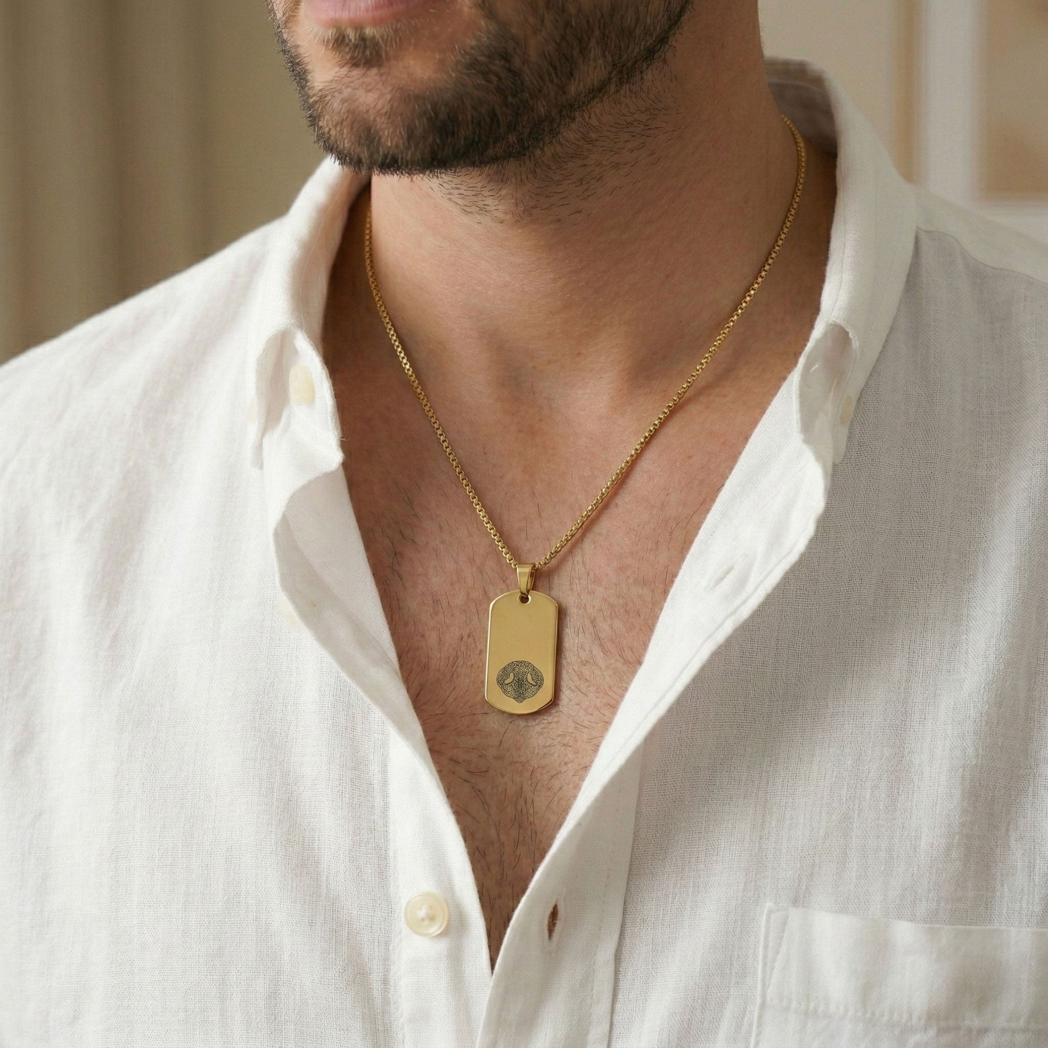 mann trägt personalisierten edelstahlanhänger, dog tag mini, in gold mit nasenschwamm gravur vom hund