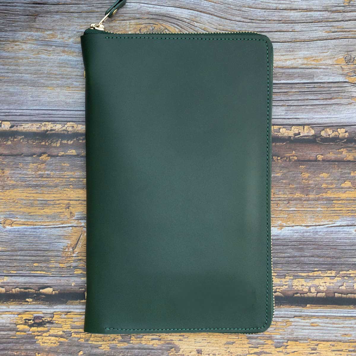 Flach liegender, handgefertigter Travel Organizer aus grünem Dickleder. Das hochwertige Reise-Etui für Familien wird von einem robusten YKK-Rundum-Reißverschluss aus Messing sicher verschlossen.