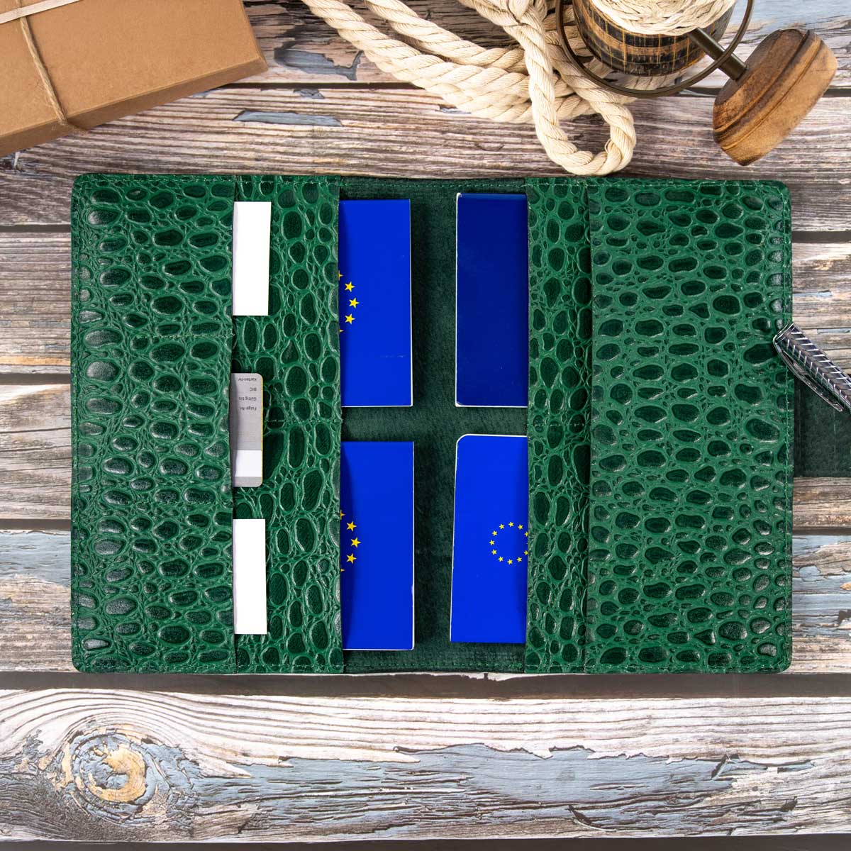 Detailansicht des befüllten grünen Kroko-Travel-Wallets. Die hochwertigen Materialien und die sauberen Nähte unterstreichen die kompromisslose österreichische Manufaktur-Qualität.