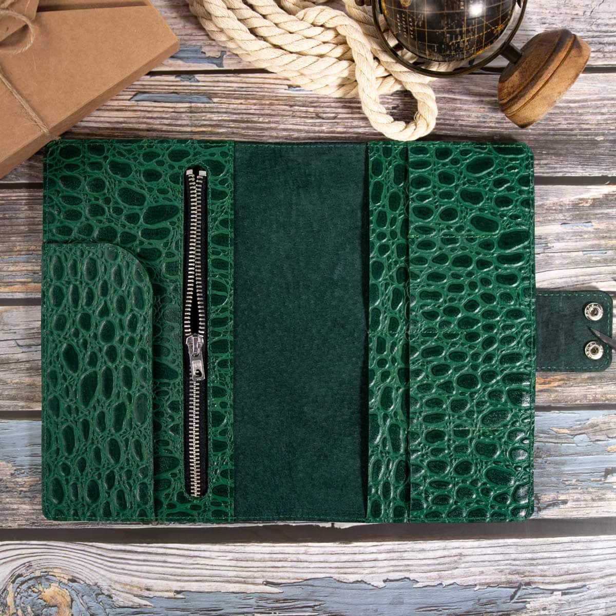 Die geöffnete Innenansicht des leeren Kroko-Travel-Wallets zeigt den eleganten Kontrast des dunkelgrünen Hirschleders.