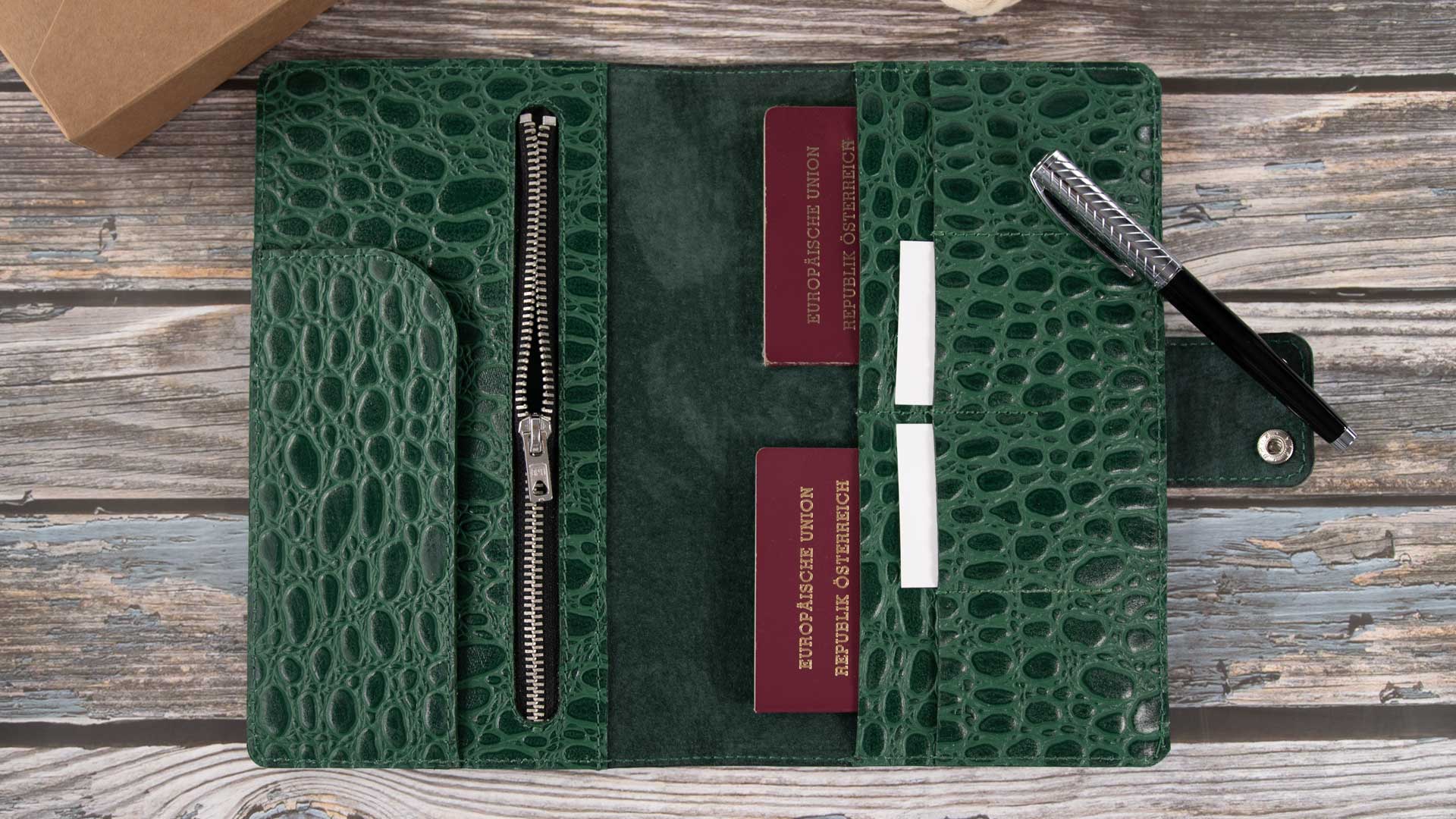 Befülltes Luxus-Reise-Etui aus Kroko-Leder mit Reisepässen, Kreditkarten und einem im großen Zippfach verstauten Smartphone