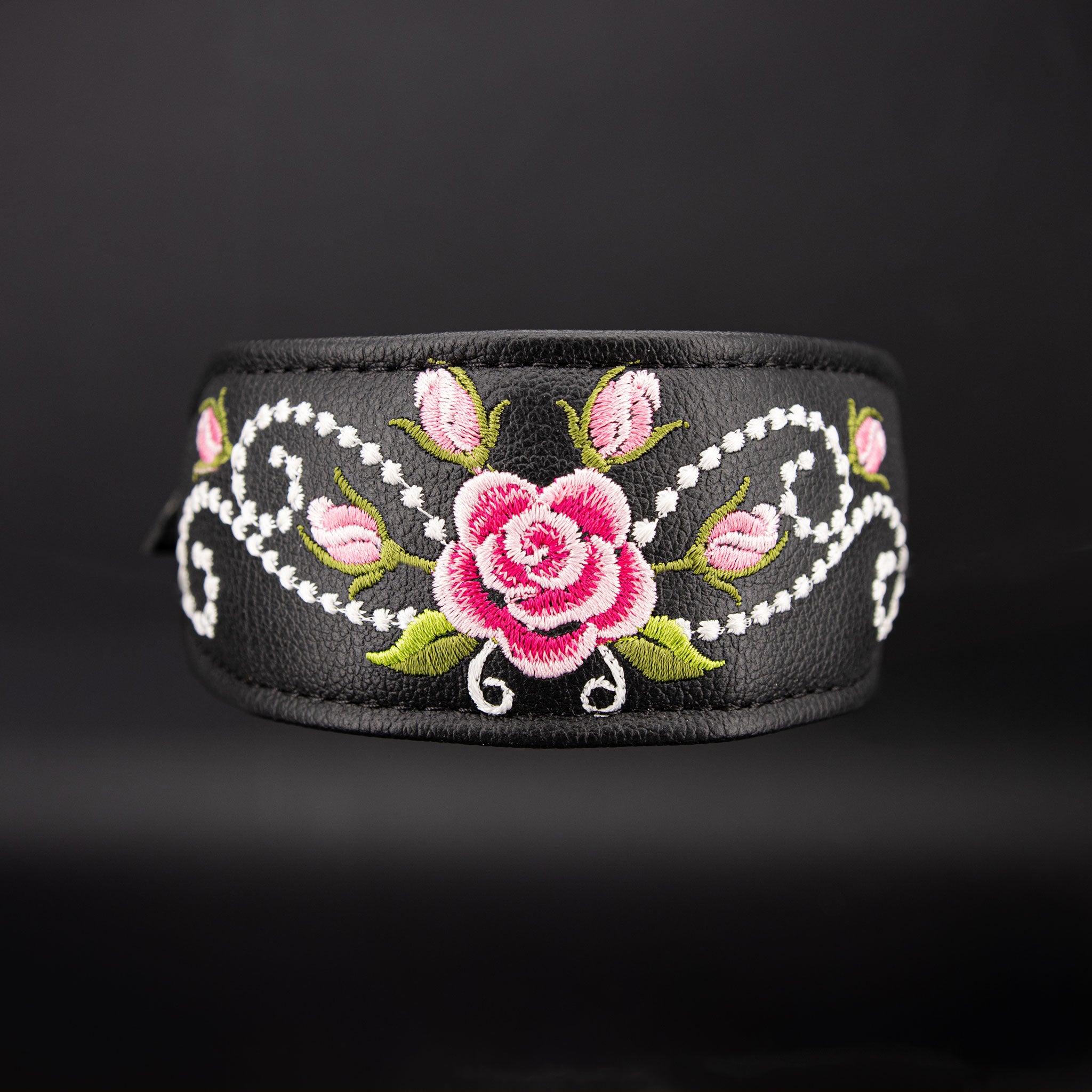 Detailaufnahme der multicoloren Rosen-Stickerei auf schwarzem Rindsnappa