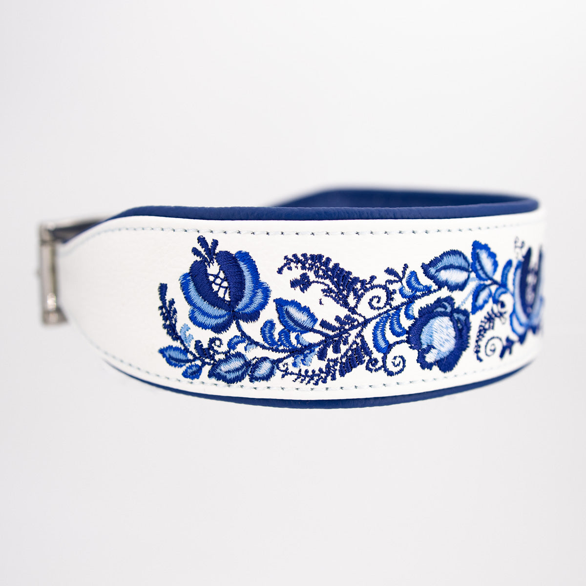 Seitenansicht des 5 cm breiten Windhundhalsbands aus weißem Leder mit großflächiger blauer Blumenstickerei und verjüngtem Halsbandende.